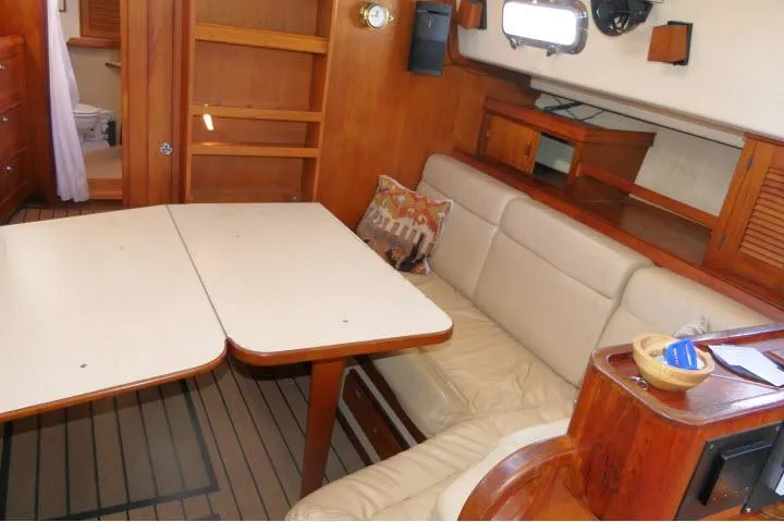 Wild Blue Yacht Photos Pics Interior of 1999 Island Packet 45 sailboat with dining area and wooden furnishings.