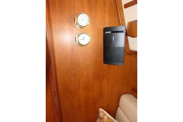 Wild Blue Yacht Photos Pics Interior of 1999 Island Packet 45 yacht with wooden panel, clock, and speaker.
