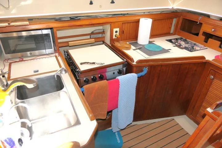 Wild Blue Yacht Photos Pics Island Packet 45 yacht kitchen, 1999 model, featuring wooden cabinetry and modern appliances.