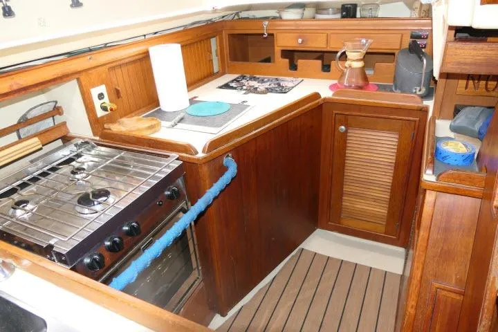 Wild Blue Yacht Photos Pics 1999 Island Packet 45 yacht kitchen with wooden cabinetry and stove.