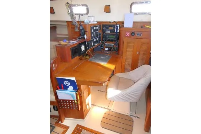 Wild Blue Yacht Photos Pics Navigation station of 1999 Island Packet 45 sailboat with wooden desk and electronics.