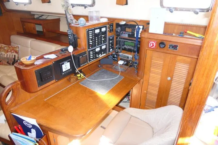 Wild Blue Yacht Photos Pics Navigation station inside a 1999 Island Packet 45 sailboat, featuring control panels and seating.