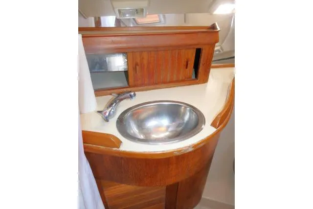 Wild Blue Yacht Photos Pics 1999 Island Packet 45 yacht bathroom with wooden cabinetry and stainless steel sink.