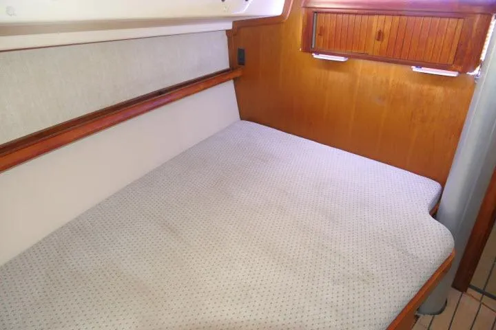 Wild Blue Yacht Photos Pics 1999 Island Packet 45 yacht interior cabin with wooden accents and comfortable bedding.