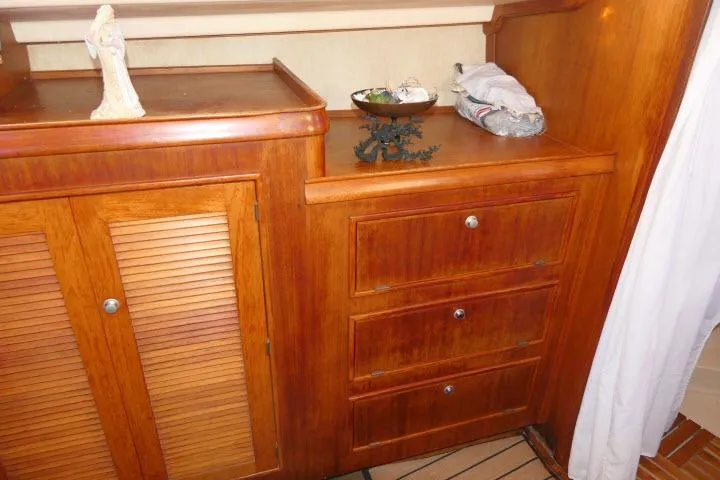 Wild Blue Yacht Photos Pics Wooden cabinetry inside a 1999 Island Packet 45 yacht, featuring drawers and a louvered door.