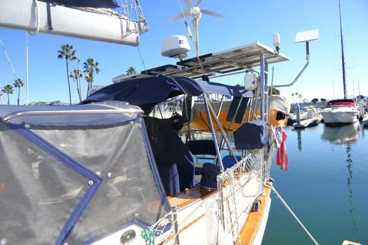 Wild Blue Yacht Photos Pics 1999 Island Packet 45 sailboat docked in a sunny marina with palm trees.