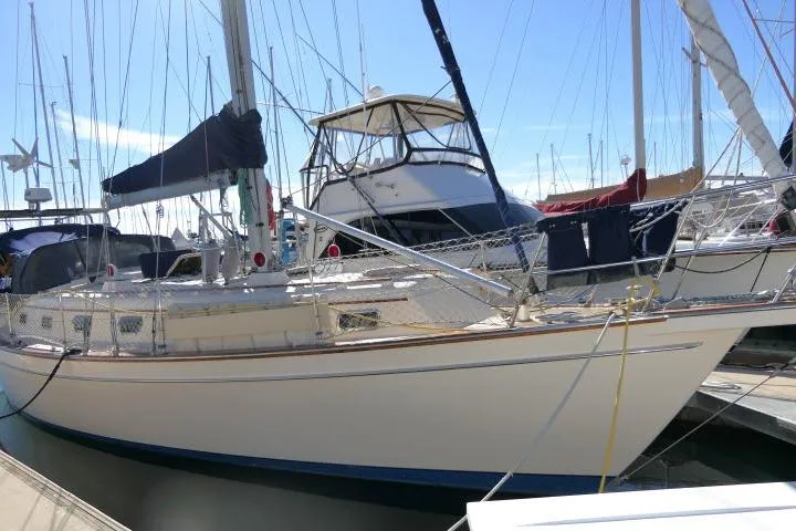 Wild Blue Yacht Photos Pics 1999 Island Packet 45 sailboat docked in a marina, surrounded by other boats.