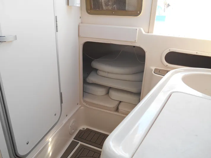 Strike Zone Yacht Photos Pics Interior storage area of 2002 Grady-White 282 Sailfish boat with stacked cushions.