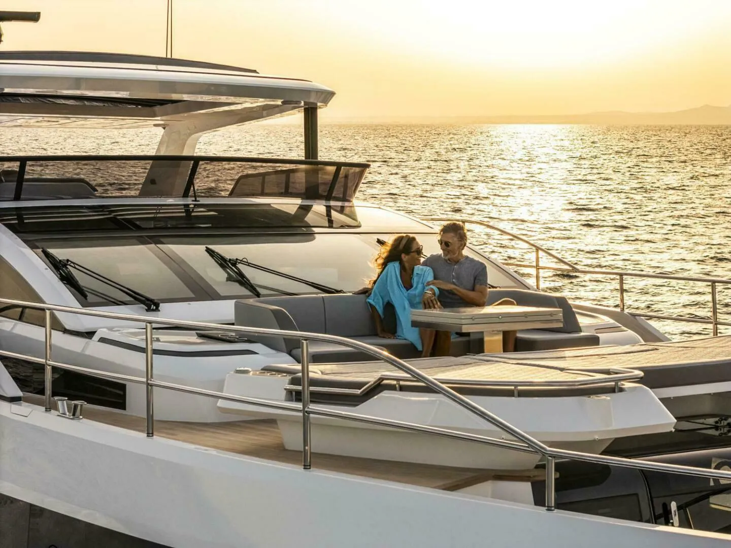 Couple enjoying sunset on Pearl 82 yacht, 2026 model, with ocean view.