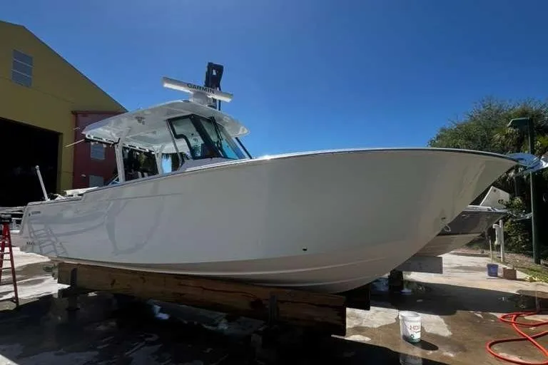  Yacht Photos Pics 2024 Bertram 28 CC boat on display outdoors under clear blue sky.