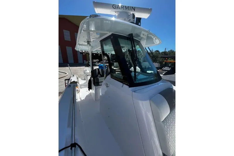  Yacht Photos Pics 2024 Bertram 28 CC boat with Garmin equipment, docked under clear blue sky.