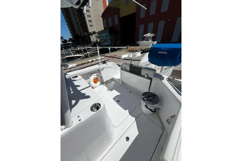  Yacht Photos Pics 2024 Bertram 28 CC boat interior with seating and equipment, docked near buildings.