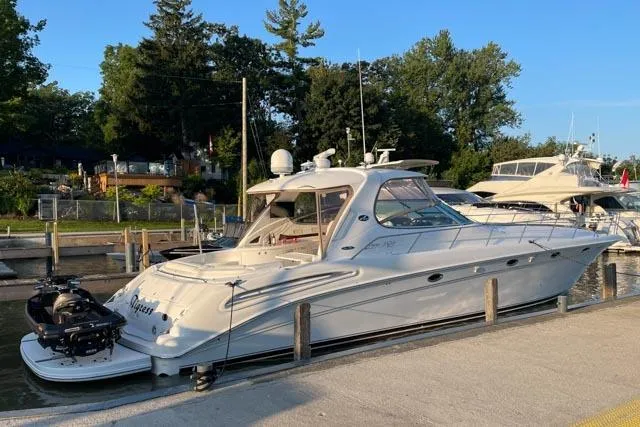Tigress Yacht Photos Pics 2002 Sea Ray 550 Sundancer yacht docked at marina, surrounded by trees and other boats.