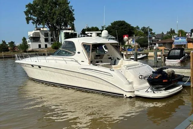 Tigress Yacht Photos Pics 2002 Sea Ray 550 Sundancer yacht docked in a marina, surrounded by calm waters.