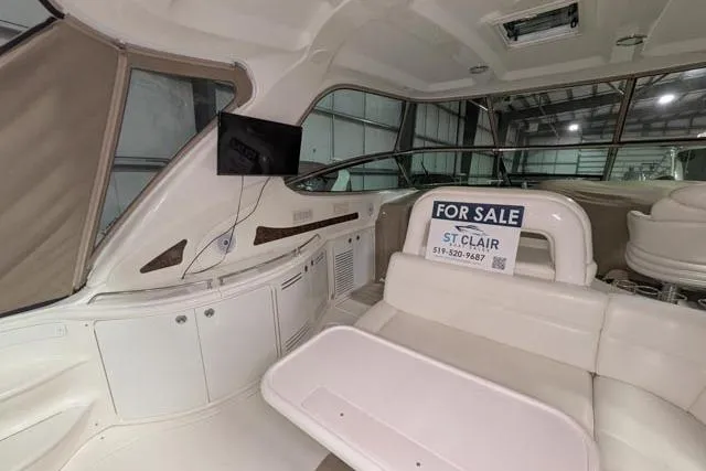 Tigress Yacht Photos Pics 2002 Sea Ray 550 Sundancer interior with "For Sale" sign, featuring white seating and modern amenities.