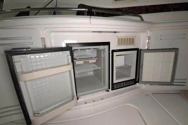 Tigress Yacht Photos Pics Open refrigerator and freezer on 2002 Sea Ray 550 Sundancer yacht, showcasing interior storage space.