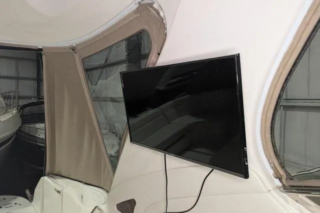 Tigress Yacht Photos Pics 2002 Sea Ray 550 Sundancer interior with mounted TV and beige canopy.