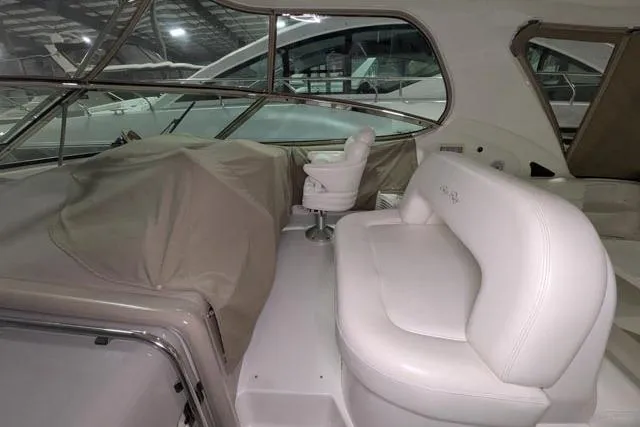 Tigress Yacht Photos Pics Interior of a 2002 Sea Ray 550 Sundancer yacht with white seating and covered controls.
