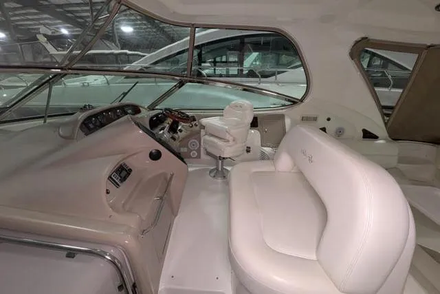 Tigress Yacht Photos Pics Interior of 2002 Sea Ray 550 Sundancer yacht with white seating and control panel.