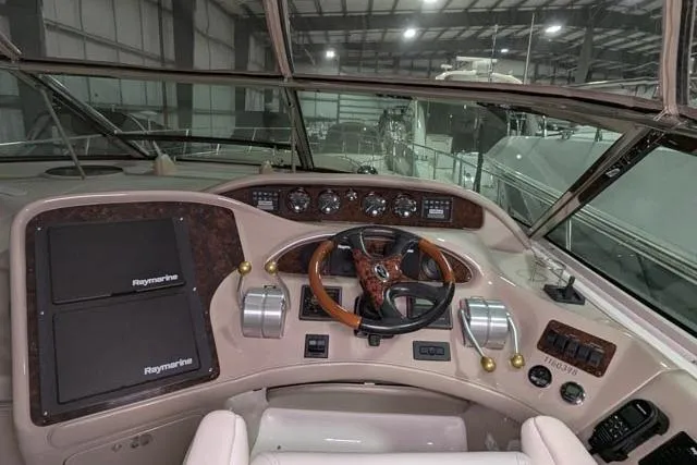 Tigress Yacht Photos Pics 2002 Sea Ray 550 Sundancer helm with Raymarine navigation, wood accents, and modern controls.