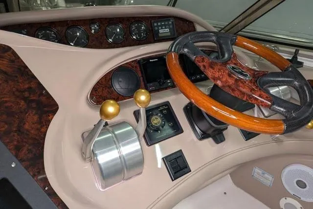 Tigress Yacht Photos Pics 2002 Sea Ray 550 Sundancer helm with wood-accented steering wheel and control panel.