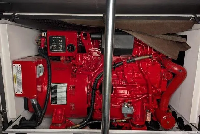 Tigress Yacht Photos Pics Engine compartment of a 2002 Sea Ray 550 Sundancer, featuring a red generator.