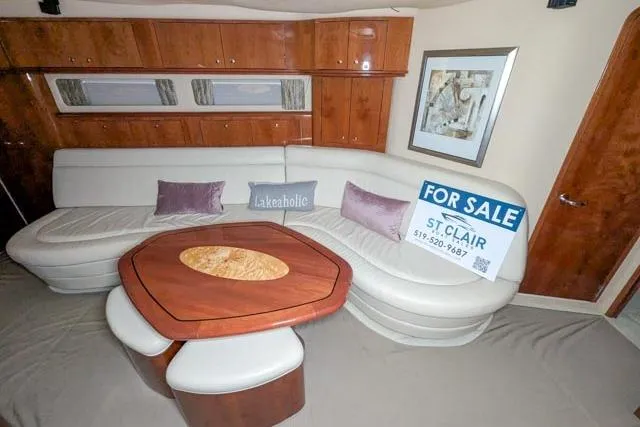 Tigress Yacht Photos Pics 2002 Sea Ray 550 Sundancer interior with curved sofa and wooden table, for sale sign visible.
