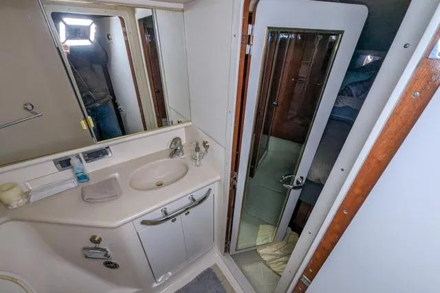 Tigress Yacht Photos Pics 2002 Sea Ray 550 Sundancer bathroom with sink, mirror, and shower door.