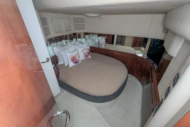 Tigress Yacht Photos Pics Luxurious cabin interior of 2002 Sea Ray 550 Sundancer yacht with cozy bed and elegant decor.