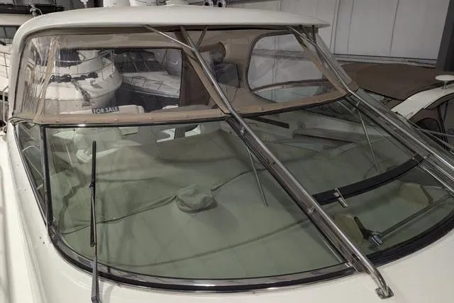 Tigress Yacht Photos Pics 2002 Sea Ray 550 Sundancer yacht with beige canopy, displayed indoors, "For Sale" sign visible.