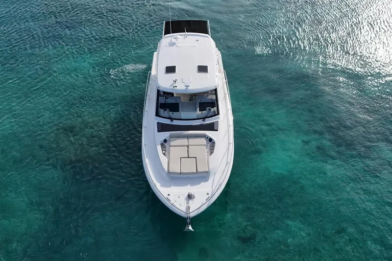  Yacht Photos Pics Aerial view of 2022 Boston Whaler 405 Conquest on clear turquoise water.