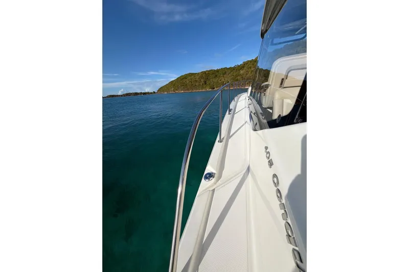  Yacht Photos Pics Boston Whaler 405 Conquest 2022 cruising near a scenic coastline.