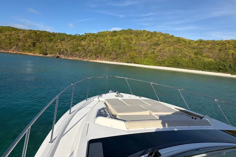  Yacht Photos Pics Boston Whaler 405 Conquest 2022 cruising near a lush, green island shoreline.