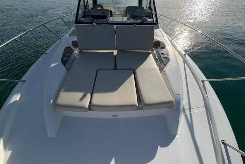  Yacht Photos Pics 2022 Boston Whaler 405 Conquest boat deck with cushioned seating, on calm water.