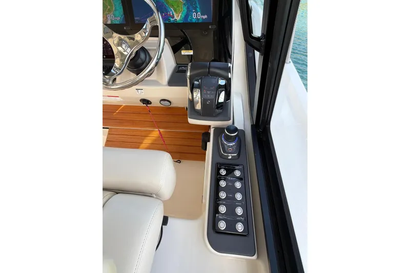  Yacht Photos Pics Control panel of 2022 Boston Whaler 405 Conquest boat with steering wheel and navigation controls.