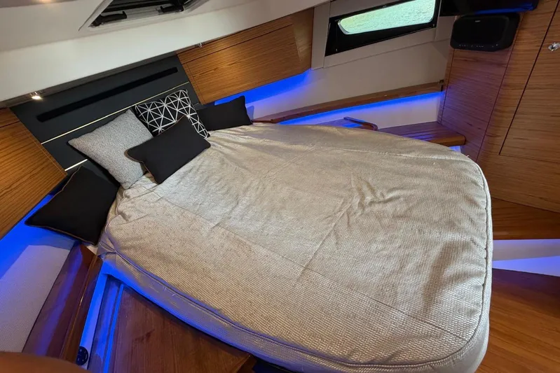  Yacht Photos Pics Luxurious cabin interior of 2022 Boston Whaler 405 Conquest with cozy bedding and ambient lighting.
