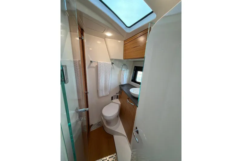  Yacht Photos Pics Luxurious bathroom in 2022 Boston Whaler 405 Conquest yacht with modern fixtures and skylight.