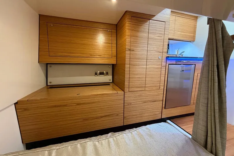  Yacht Photos Pics Interior of 2022 Boston Whaler 405 Conquest, featuring modern wood cabinetry and compact kitchen amenities.