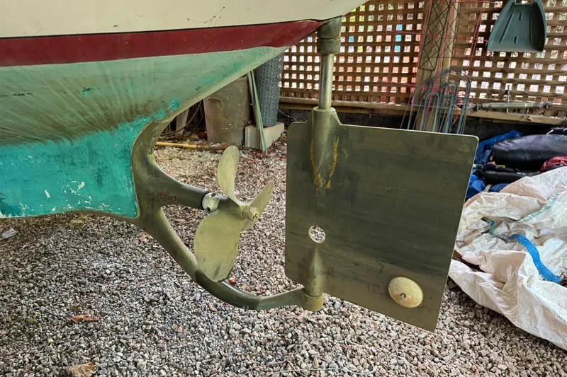 Annie Yacht Photos Pics Propeller and rudder of 1989 Elco 30 Fantail Electric Launch on gravel surface.