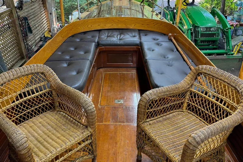 Annie Yacht Photos Pics Interior of 1989 Elco 30 Fantail Electric Launch with wicker chairs and cushioned seating.