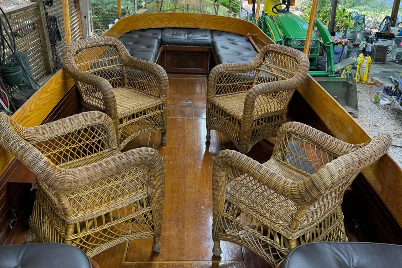 Annie Yacht Photos Pics Interior of 1989 Elco 30 Fantail Electric Launch with wicker chairs and wooden flooring.