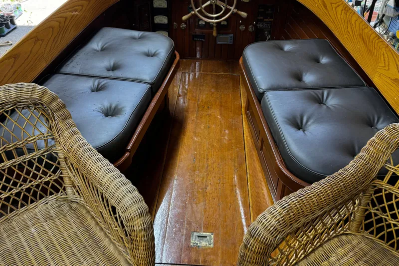 Annie Yacht Photos Pics Interior of 1989 Elco 30 Fantail Electric Launch with wicker chairs and cushioned seating.