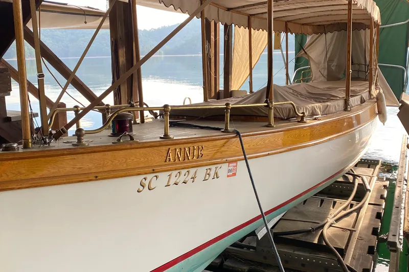 Annie Yacht Photos Pics Elco 30 Fantail Electric Launch, 1989, docked with canopy, serene lake background.