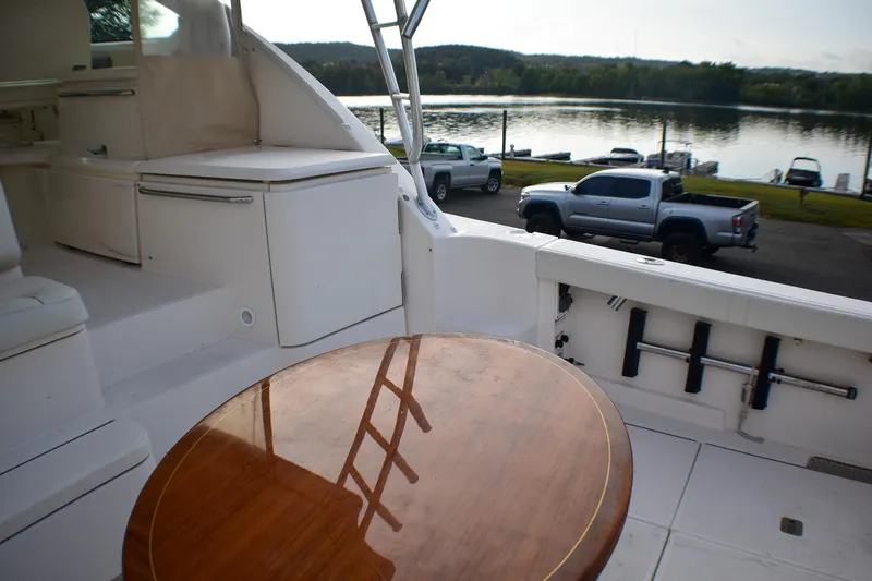 Fifth Case Yacht Photos Pics 2016 Tiara Yachts 4300 Open interior with wooden table, overlooking a serene waterfront.