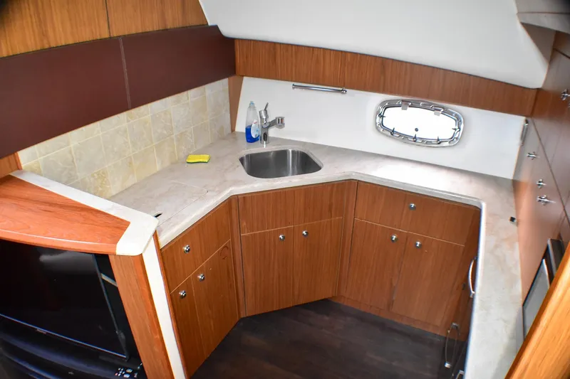 Fifth Case Yacht Photos Pics 2016 Tiara Yachts 4300 Open galley with wood cabinetry and stainless steel sink.