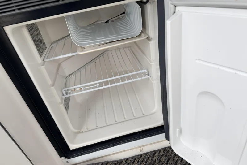  Yacht Photos Pics Open refrigerator inside 2006 Sea Ray 340 Sundancer boat, showing empty shelves.