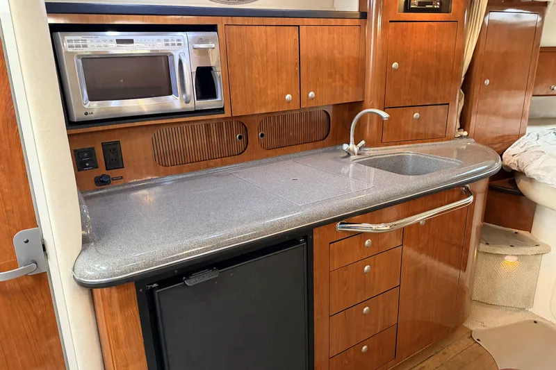  Yacht Photos Pics 2006 Sea Ray 340 Sundancer galley with microwave, sink, and wooden cabinetry.