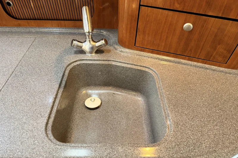  Yacht Photos Pics 2006 Sea Ray 340 Sundancer kitchen sink with modern faucet and wooden cabinetry.