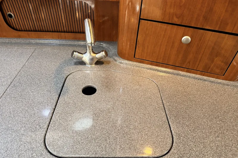  Yacht Photos Pics 2006 Sea Ray 340 Sundancer kitchen sink with faucet and wooden cabinetry.