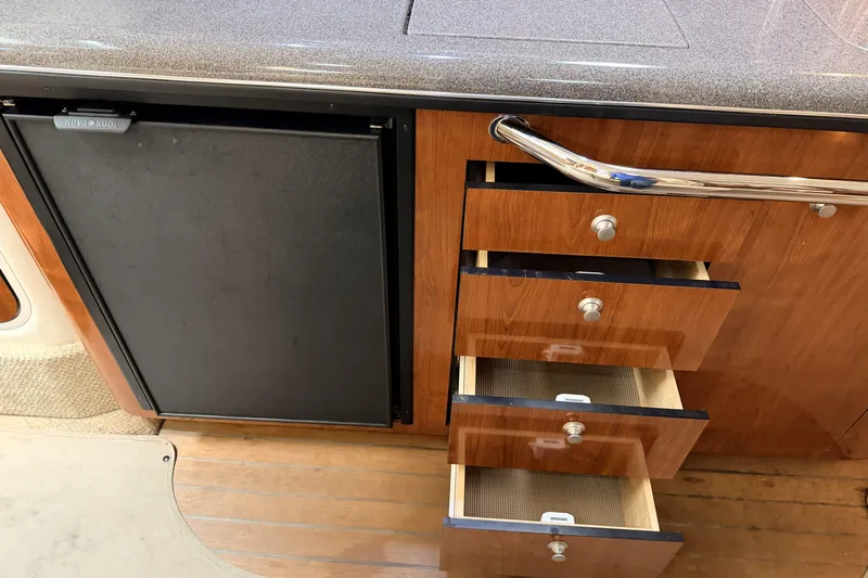  Yacht Photos Pics Interior of 2006 Sea Ray 340 Sundancer with wooden drawers and a compact fridge.